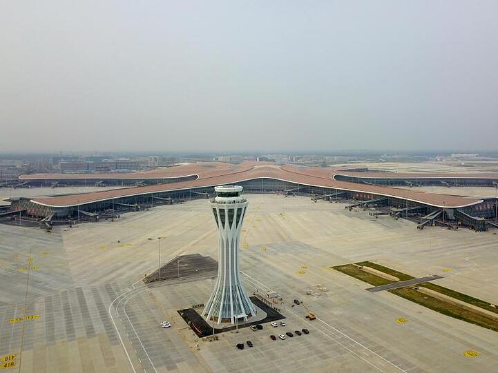 Der Flughafen in Daxing rund 50 Kilometer südlich der Innenstadt ist gemessen an der Gebäudefläche der größte Flughafen der Welt. Mit 700.000 Quadratmetern hat er die Fläche von 98 Fußballfeldern. Die Reisenden sollen mit einer Schnellbahn in 20 Minuten in die Innenstadt gebracht werden können.