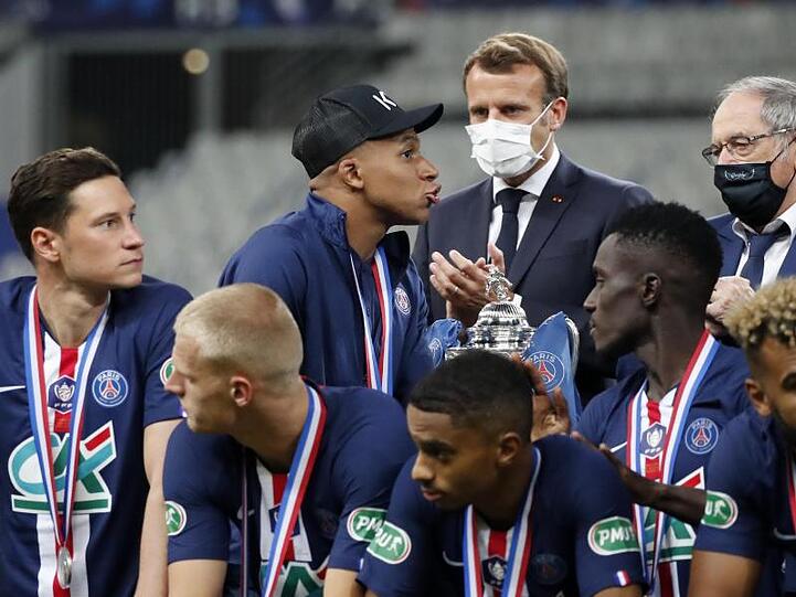 Musste die Glückwünsche von Präsident Emmanuel Macron (M) zum PSG-Pokalsieg auf Krücken entgegennehmen: Kylian Mbappé (3.v.l.).