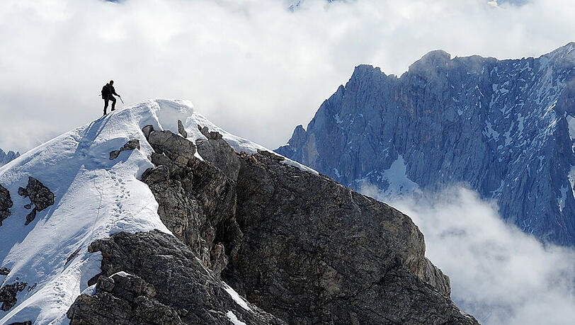 Ein Bergsteiger geht auf dem Jubiläumsgrat (2750 Meter) unweit des Zugspitzgifels durch den Schnee. Ein Bergsteiger geht auf dem Jubiläumsgrat (2750 Meter) unweit des Zugspitzgifels durch den Schnee.