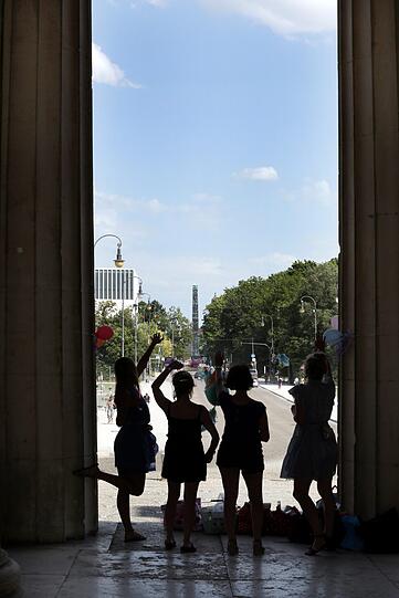 Scherenschnitt: Vier Mädels feiern unter den Propyläen Open-Air-Geburtstag &ndash; ganz hinten grüßt der Obelisk am Karolinenplatz.
