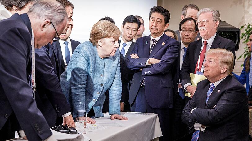 Ein Bild vom G7-Gipfel im kanadischen Charlevoix im Juni, das in den sozialen Netzwerken tausendfach geteilt wird: Kanzlerin Angela Merkel (M.) steht im Zentrum der Macht, stützt sich auf dem Tisch auf, sieht auf US-Präsident Trump (r.) herunter. Neben ihr: der französische Präsident Emmanuel Macron (2 .v. l.) und Japans Ministerpräsident Shinzo Abe (4. v.r. ).