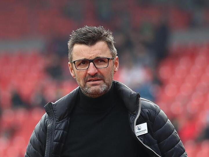 Der Nürnberger Trainer Michael Köllner geht vor Spielbeginn über den Platz. Foto: Daniel Karmann/Archiv