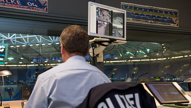 Ein Polizeibeamter sitzt in der Polizei-Leitstelle der Videoüberwachung in der Veltins Arena beim Spiel zwischen dem FC Schalke 04 und dem FC Bayern. Ein Polizeibeamter sitzt in der Polizei-Leitstelle der Videoüberwachung in der Veltins Arena beim Spiel zwischen dem FC Schalke 04 und dem FC Bayern.