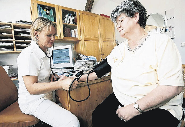 Patientin beim Blutdruckmessen in der Hausarzt-Praxis.