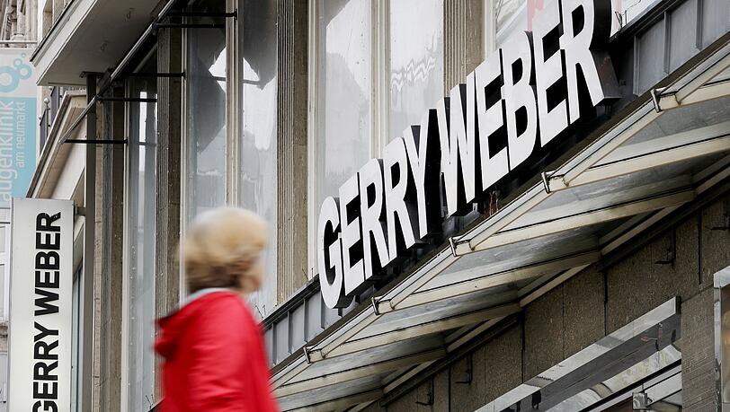 Eine Passantin vor einer Filiale des Modeherstellers Gerry Weber in Köln: Der Modeherstaeeler will zurück aus Kurs.
