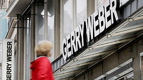 Eine Passantin vor einer Filiale des Modeherstellers Gerry Weber in Köln: Der Modeherstaeeler will zurück aus Kurs.