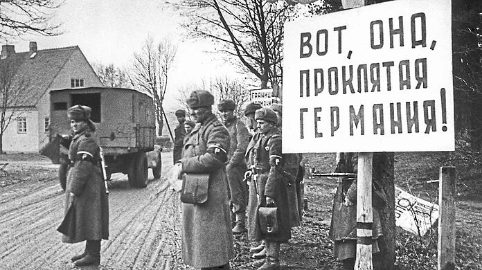 Irgendwo in Ostpreußen im Januar 1945: Sowjetische Armeeangehörige befinden sich im Deutschen Reichsgebiet. Auf dem Schild steht sinngemäß: "Bitte sehr, das verdammte Deutschland".