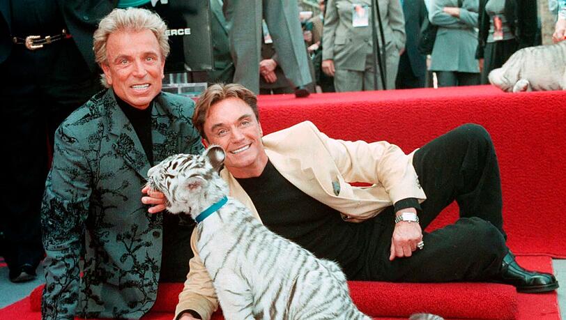 Siegfried Fischbacher (l) und Roy mit einem weißen Tigerbaby. Die beiden Magier starben 2020 und 2021 und sollen jetzt gemeinsam ihre letzte Ruhe finden. Siegfried Fischbacher (l) und Roy mit einem weißen Tigerbaby. Die beiden Magier starben 2020 und 2021 und sollen jetzt gemeinsam ihre letzte Ruhe finden.