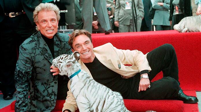 Siegfried Fischbacher (l) und Roy mit einem weißen Tigerbaby. Die beiden Magier starben 2020 und 2021 und sollen jetzt gemeinsam ihre letzte Ruhe finden.
