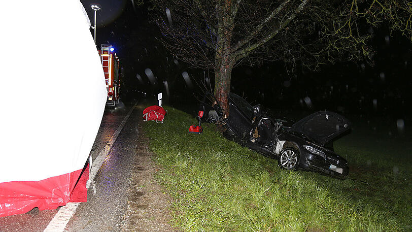 Schreckliche Bilder aus Icking: Der BMW kam von der Straße ab und prallte gegen einen Baum. Zwei 19-jährige Männer starben.