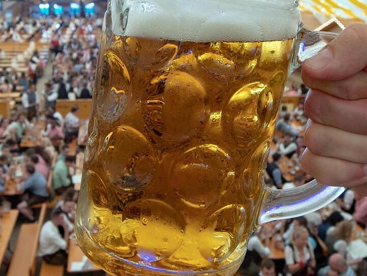 Eine Maß Bier wird in einem Festzelt auf dem Gelände des Gäubodenvolksfestes hochgehalten. Foto: Armin Weigel/dpa/Archivbild