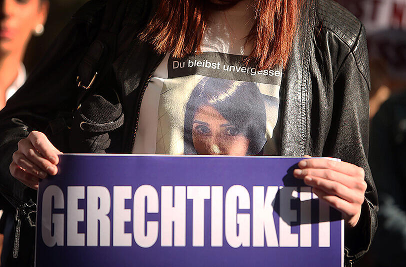 Menschen halten vor dem Landgericht in Darmstadt Mahnwache.