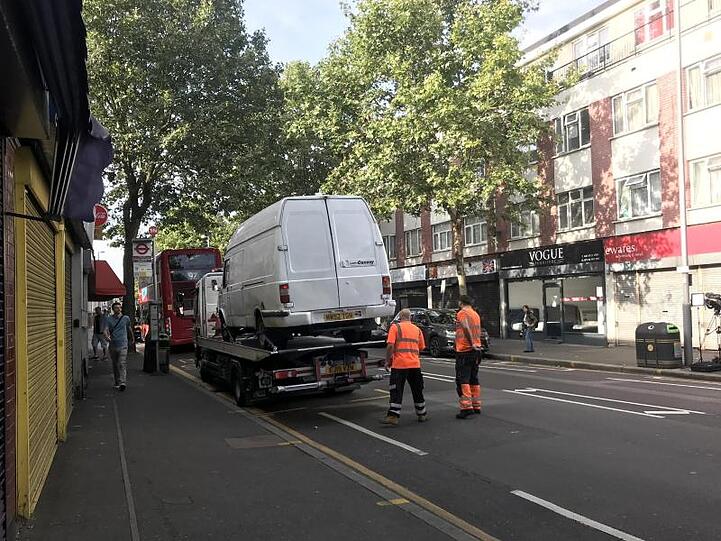 Ein Lieferwagen wird von zwei Männern auf einen Autotransporter verladen. Ein Mann hat in der Nacht zuvor mit einem Messer einen Polizisten angegriffen, als dieser den Lieferwagen angehalten hatte.