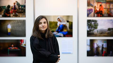 Fotojournalistin Elise Blanchard steht vor den pr&auml;mierten Bildern.