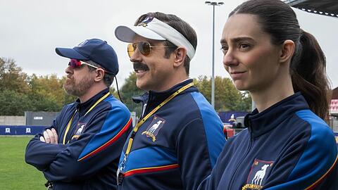 Ted Lasso (Jason Sudeikis, Mitte) sieht sich in Staffel vier einer g&auml;nzlich neuen Aufgabe gegen&uuml;ber, die er mit gewohnter Zuversicht angeht.