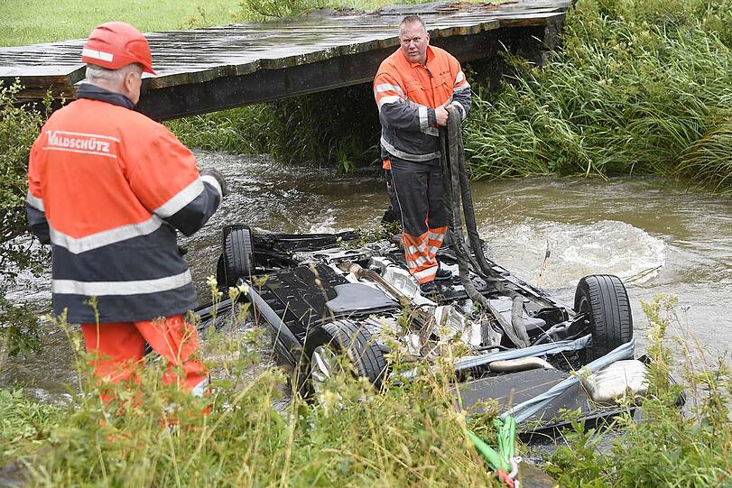 Bei Bayerischzell am Schliersee landet ein Passat kopfüber in einem stark überfluteten Bach. Der Fahrer kann in letzter Sekunde gerettet werden. Die Bilder des Unfalls.