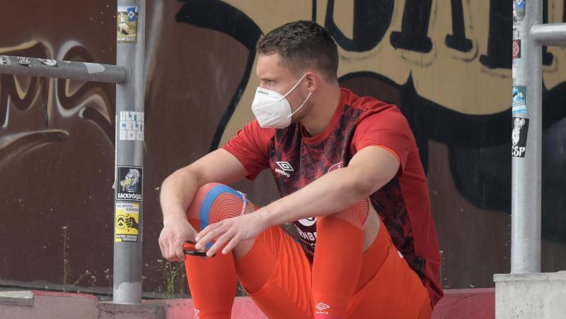 Nürnbergs Torwart Christian Mathenia sitzt nach seiner Roten Karte mit Maske auf der Tribüne. Foto: Axel Heimken/dpa - Pool/dpa/Archivbild Nürnbergs Torwart Christian Mathenia sitzt nach seiner Roten Karte mit Maske auf der Tribüne. Foto: Axel Heimken/dpa - Pool/dpa/Archivbild
