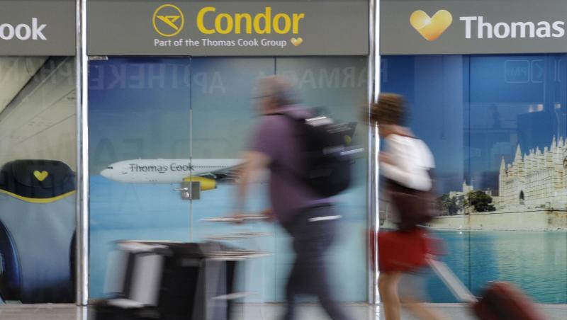 Passagiere gehen an einem Büro von Condor und Thomas Cook am Flughafen Palma de Mallorca vorbei. Passagiere gehen an einem Büro von Condor und Thomas Cook am Flughafen Palma de Mallorca vorbei.