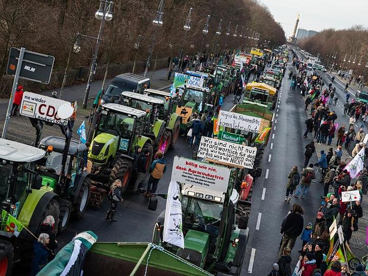 Demonstranten und Bauern mit ihren Traktoren stehen auf der Straße des 17. Juni in Berlin.