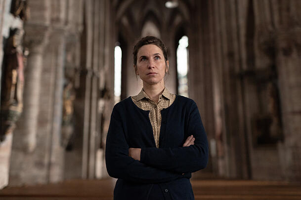 Die Vikarin (Lisa Oertel) wird von Wanda Goldwasser in der Kirche befragt.