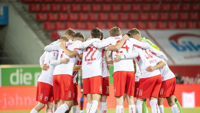 Die Spieler von Regensburg stehen vor einem Spiel im Kreis zusammen.