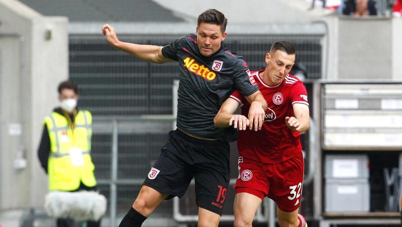 Regensburgs Andreas Albers (l) und der Düsseldorfer Robert Bozenik kämpfen um den Ball.