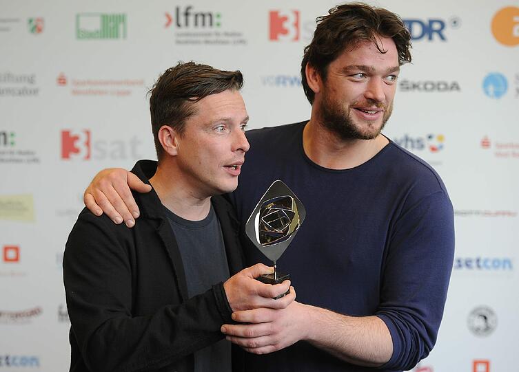 Die Schauspieler Florian Panzner (l) und Ronald Zehrfeld (r) posieren dem Preis in der Kategorie "Fiktion" für den Film "Mord in Eberswalde".