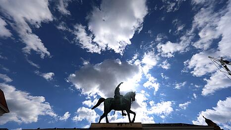 Einer der wenigen Prachtpl&auml;tze M&uuml;nchens: Kurf&uuml;rst Maximilian I. gr&uuml;&szlig;t hoch zu Ross vor wei&szlig;-blauem Himmel.