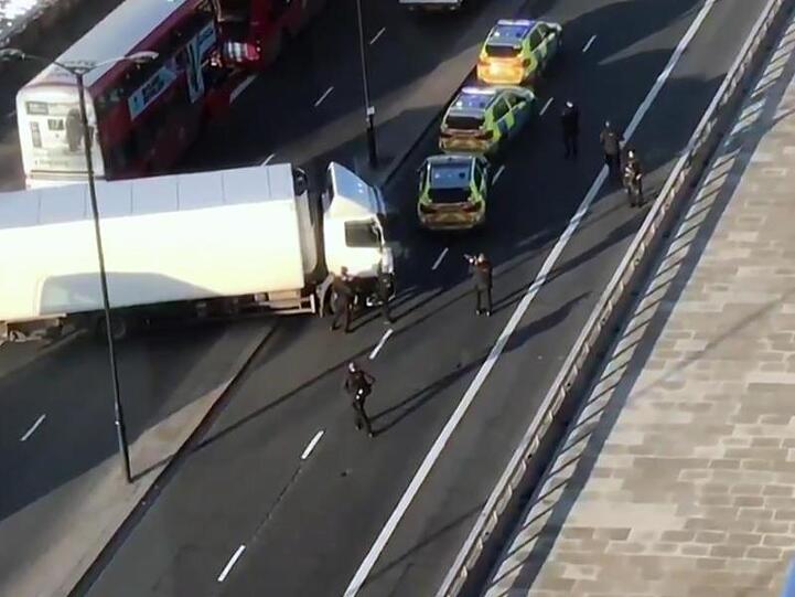 Bewaffnete Polizisten umstellen auf der London Bridge einen Lkw.