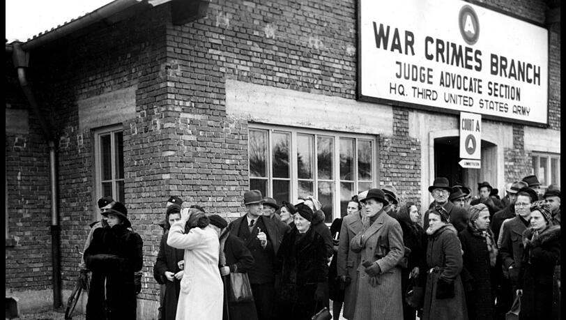 Dachau am 13. Dezember 1945: Angehörige und Freunde der Angeklagten im Prozess wegen Gräueltaten in den Konzentrationslagern Dachau und Buchenwald warten vor den Baracken auf die Beschuldigten.