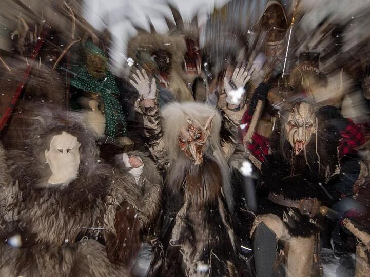 Teilnehmer mit gruseligen Masken nehmen in München (Bayern) am traditionellen Krampuslauf teil. Foto: Peter Kneffel/Archiv