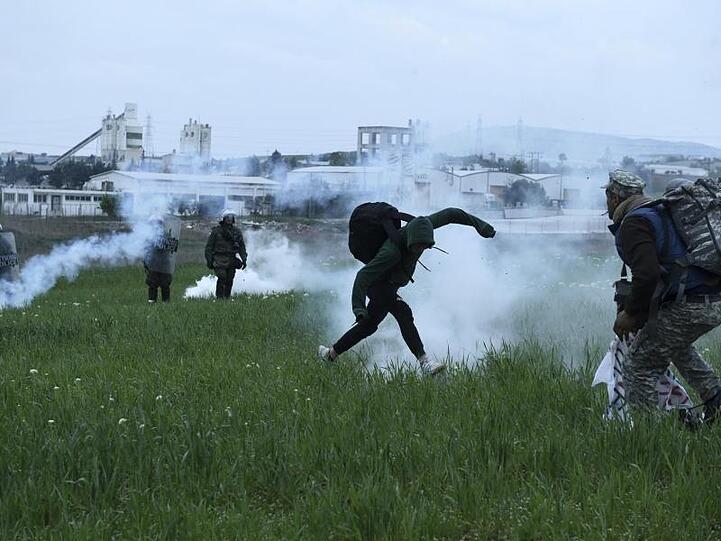 Protestierende Migranten bringen sich bei Zusammenstößen mit der Polizei in Sicherheit.