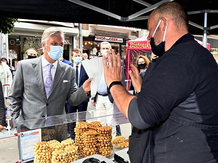König Philippe von Belgien (l) mit Mundschutz an einem Waffel-Stand.