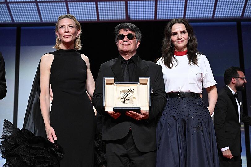 Palme d&lsquo;Or-Gewinner Jafar Panahi mit Cate Blanchett (li.) und Jury-Pr&auml;sidentin 2025 Juliette Binoche.