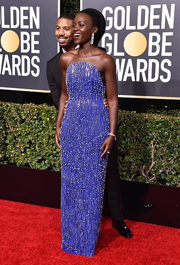 Flop: Ein Figurenschmeichler ist das Kleid von Calvin Klein by Appointment definitiv nicht. Selbst bei der super-schlanken Lupita Nyong'o, die mit Michael B. Jordan posiert, trägt die blaue Abendrobe auf.
