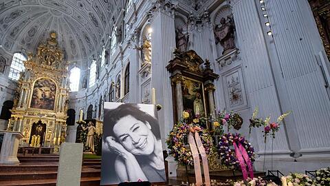 Kerzen, Blütenblätter, Kränze und ein Porträt von Hannelore Elsner in der Kirche St. Michael in München.
