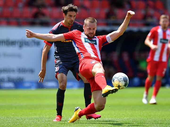 Patrick Mainka (l) vom 1. FC Heidenheim behauptet den Ball gegen den Regensburger Sebastian Stolze.