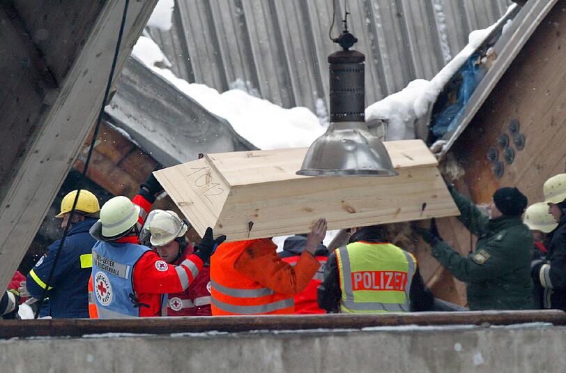 Helfer decken in der eingestürtzten Eissporthalle in Bad Reichenhall den Sarg eines soeben gefundenen Verschütteten ab. am 2. Januar jährt sich die Eishallen-Katastrophe zum 10. Mal.