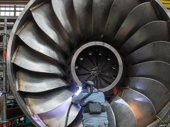 Ein Angestellter in einer Maschinenbaufirma arbeitet an einer Wasserturbine.