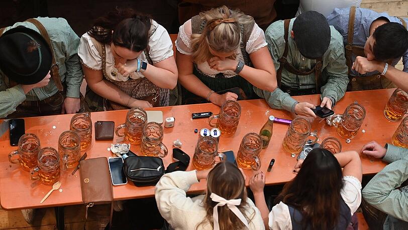Oktoberfest-Gäste schnupfen eine Prise Schnupftabak.