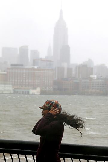 Erinnerungsfoto mit waagerechter Frisur: In Hoboken, New Jersey, lässt sich eine Frau vor der New Yorker Skyline ablichten. Der starke Wind ist ein Vorbote auf Hurrikan "Sandy".