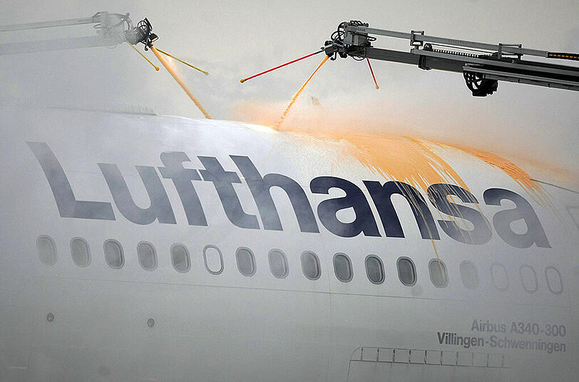 Ein Flugzeug der Lufthansa wird von Spezialfahrzeugen enteist.