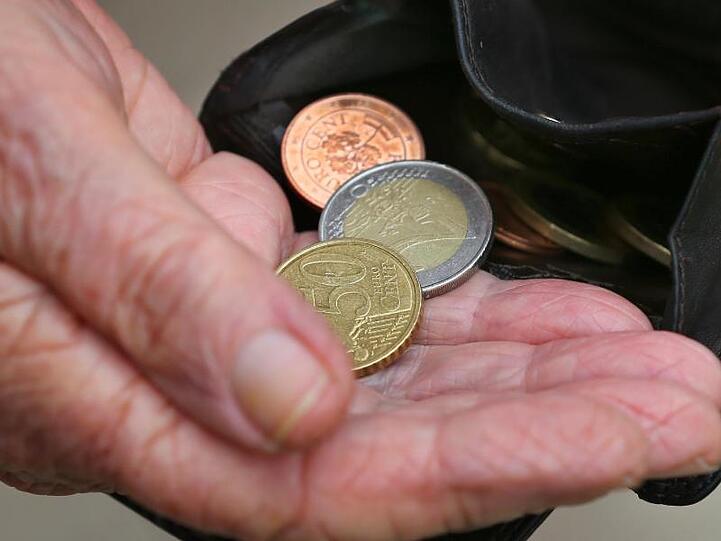 Eine Rentnerin hält einen Geldbeutel mit verschiedenen Euromünzen.