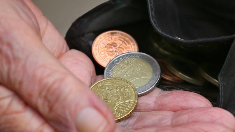 Eine Rentnerin hält einen Geldbeutel mit verschiedenen Euromünzen. Eine Rentnerin hält einen Geldbeutel mit verschiedenen Euromünzen.