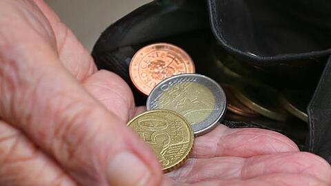 Eine Rentnerin hält einen Geldbeutel mit verschiedenen Euromünzen.