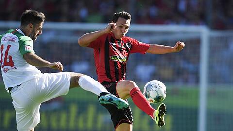 Jan Moravek (l) von Augburg versucht Nicolas Höfler (r) von Freiburg den Ball abzunehmen. Foto: Patrick Seeger