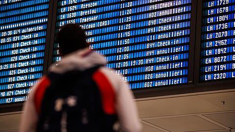 Zahlreiche Flüge sind auf einer Anzeigetafel in einer Abflughalle am Münchner Flughafen als „annulliert“ ausgewiesen.