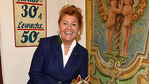 Gabriele Weishäupl im Bier- und Oktoberfestmuseum mit einem antiken Karussellpferdl