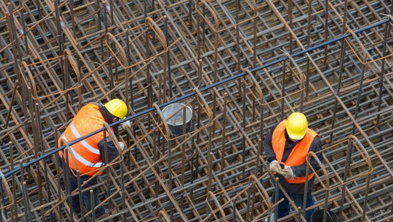 Bauarbeiter errichten auf einer Baustelle ein Stahlgeflecht. Bauarbeiter errichten auf einer Baustelle ein Stahlgeflecht.