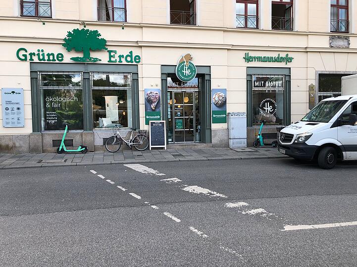 Zwei E-Scooter stehen auf dem Gehweg vor einem Geschäft in der Frauenstraße.